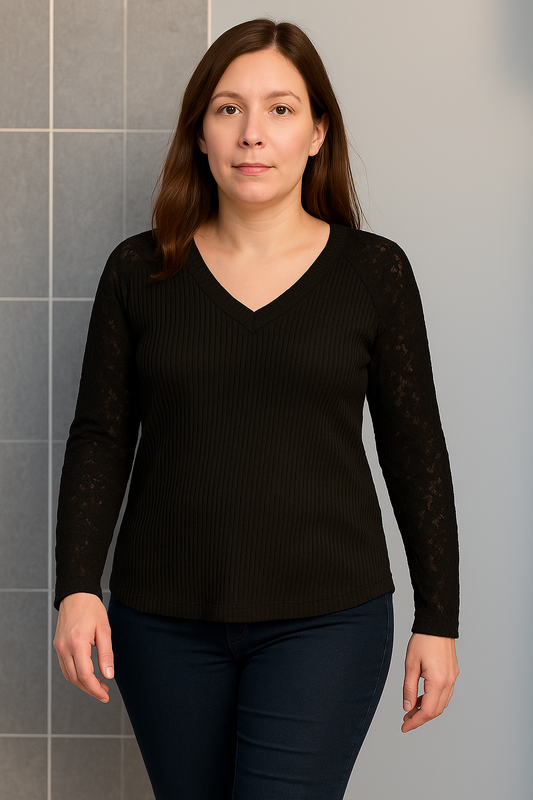 Woman wearing a black ribbed V-neck jumper with sheer lace sleeves
