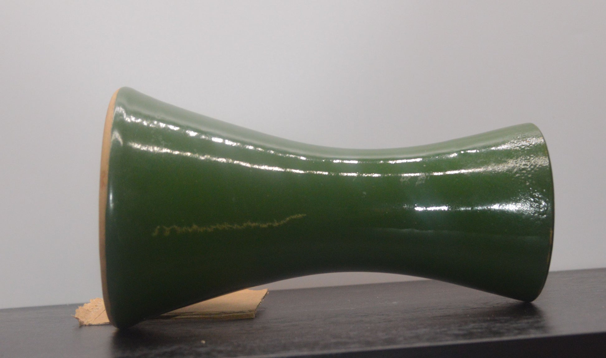 Close-up of green Denby vase showing glaze imperfections and ceramic texture.
