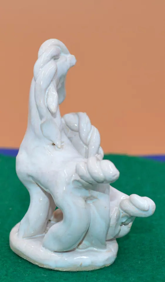 White ceramic figurine of two abstract, twisted horses