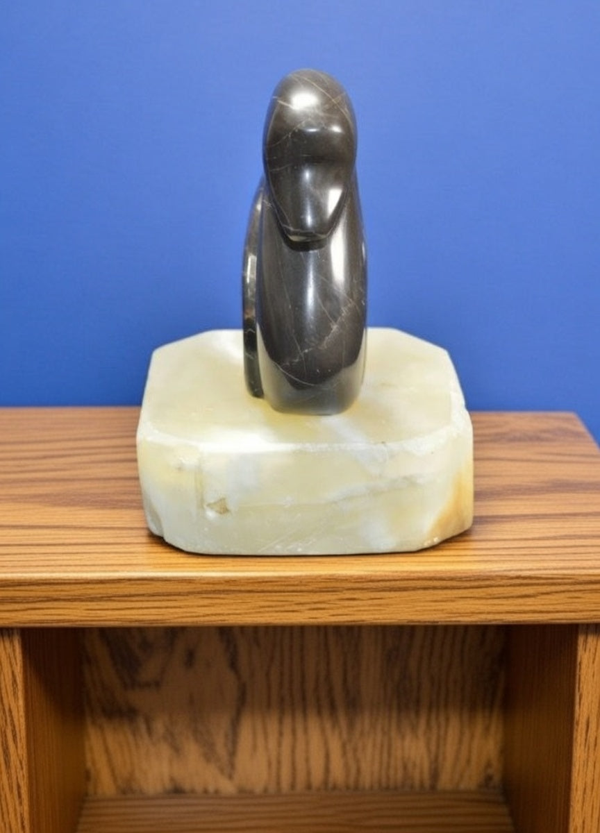 Front view of polished dark stone swan figurine with natural veining on white marble base, decorative natural rock bird ornament displayed on wooden shelf.