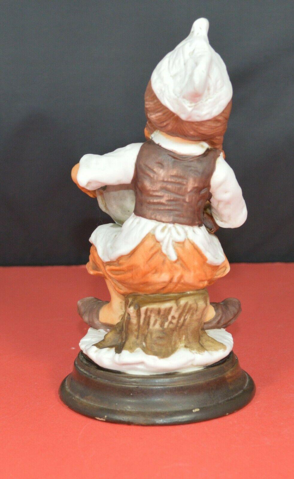 TWO DIFFERENT DECORATIVE FIGURINES OF A YOUNG COOK SITTING ON A TREE STUMP - TMD167207