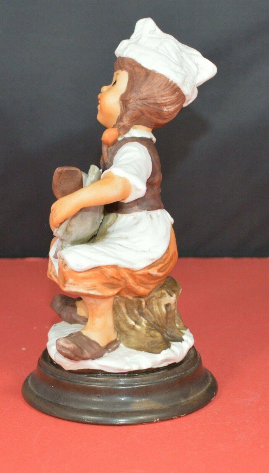 TWO DIFFERENT DECORATIVE FIGURINES OF A YOUNG COOK SITTING ON A TREE STUMP - TMD167207