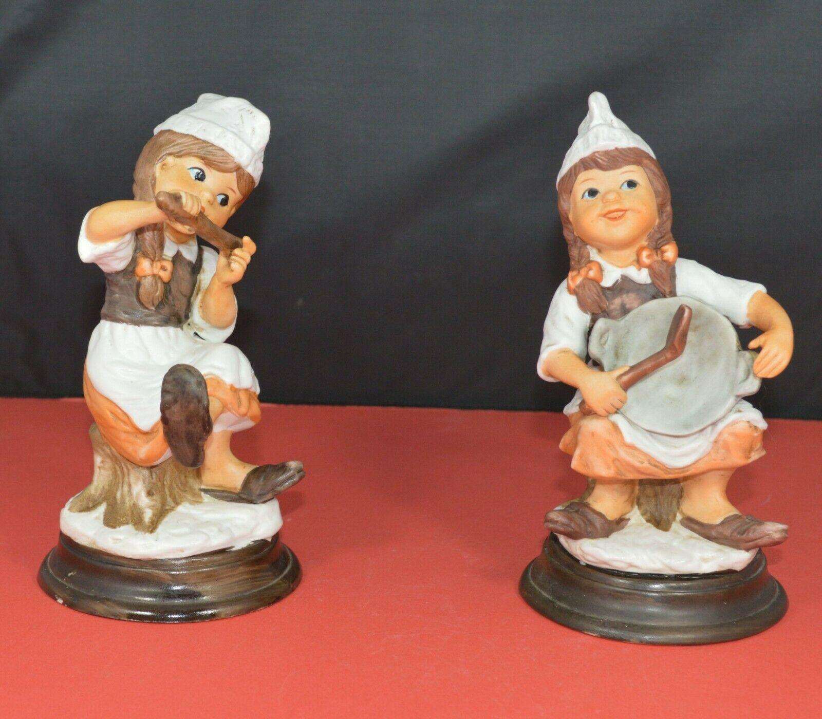 TWO DIFFERENT DECORATIVE FIGURINES OF A YOUNG COOK SITTING ON A TREE STUMP - TMD167207