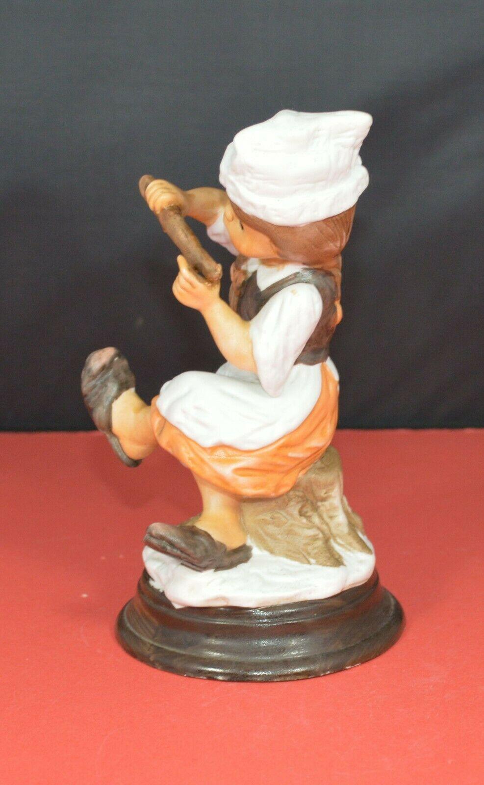 TWO DIFFERENT DECORATIVE FIGURINES OF A YOUNG COOK SITTING ON A TREE STUMP - TMD167207